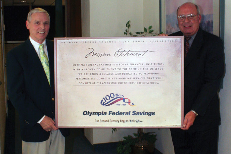 Ed Wack and Wayne Staley holding the OlyFed mission statement for 100 year celebration.