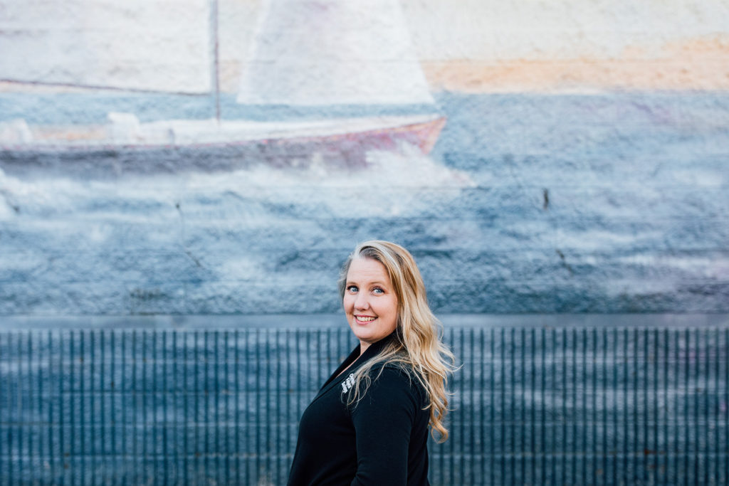 OlyFed Loan Officer, Rebecca Bonneville, in front of a maritime mural in Belfair, Washington.