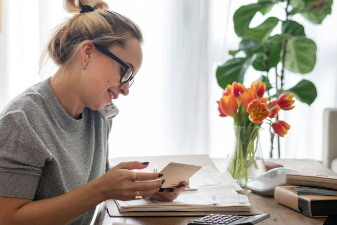 Young woman doing finances over the phone