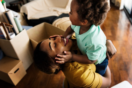 Smiling woman hugging a child in New Home Living Room