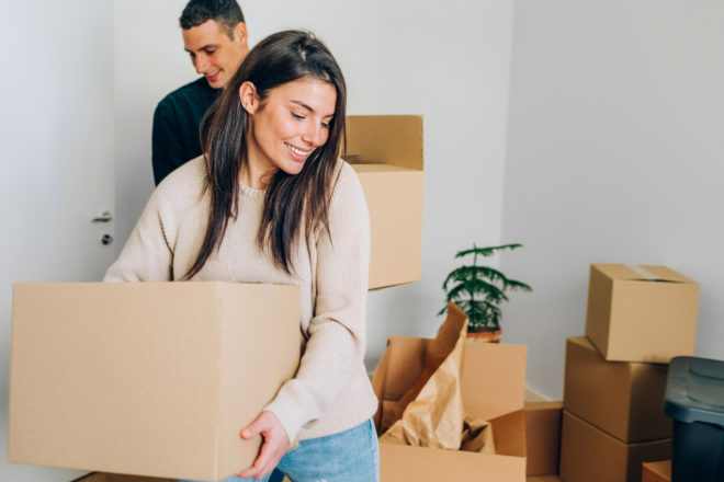 Woman moving packing box in new home