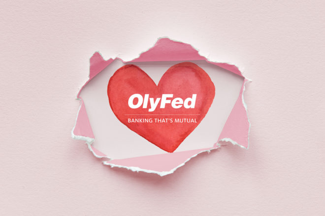 Heart showing through a piece of paper that reads OlyFed