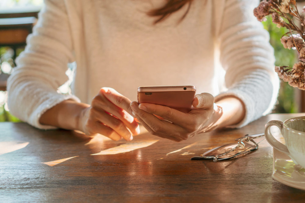 Woman holding smartphone at table