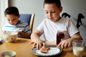 Special needs child at table eating breakfast