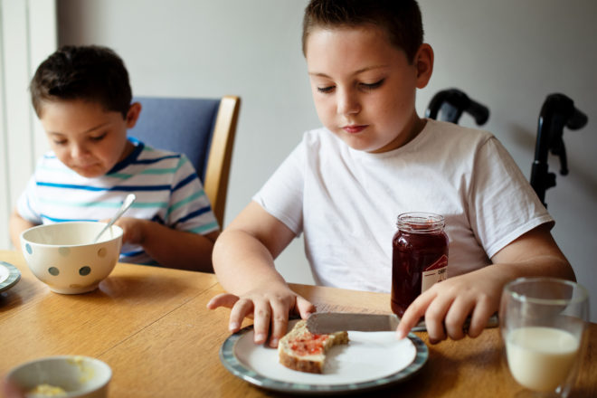Special needs child at table eating breakfast
