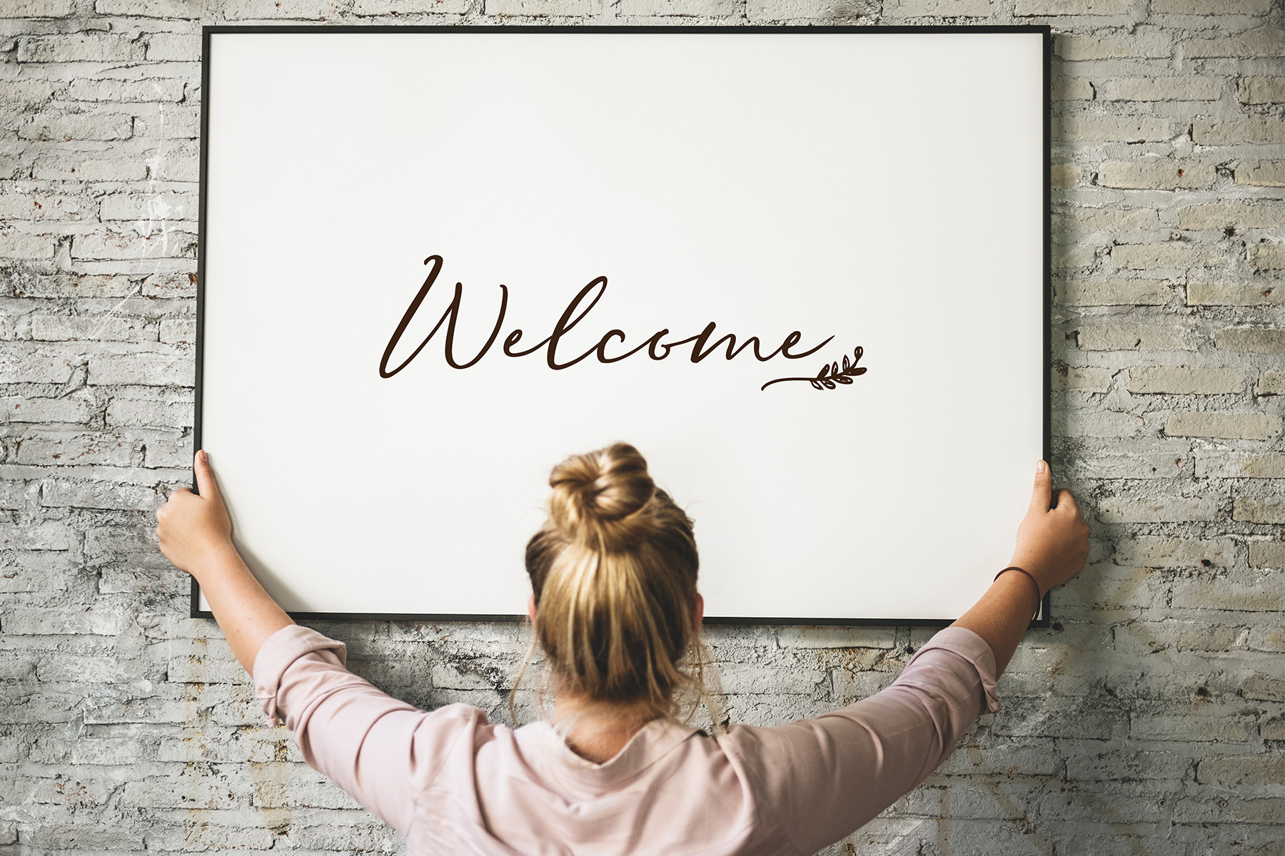 Woman holding welcome sign