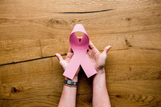 Hands holding a breast cancer symbol