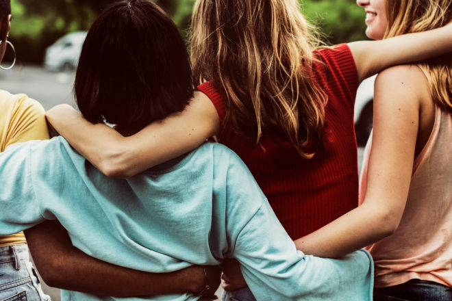 Teenage girls laughing and hugging