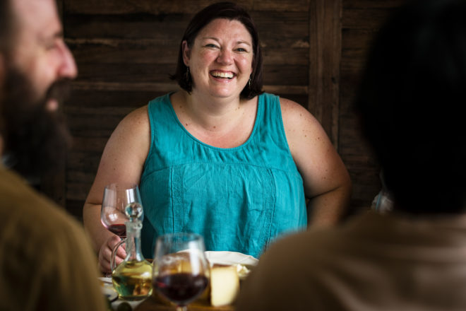 Woman at dining table laughing with family