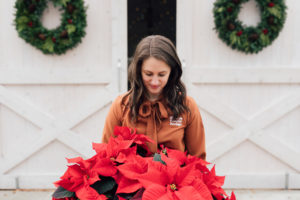 Taryn Colborn of Olympia Federal Savings at HayDay Heritage Farm holding poinsettias