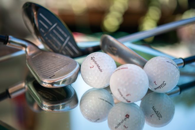 Golf balls and clubs on a table
