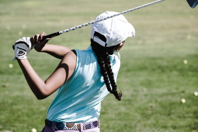 A young golfer swinging