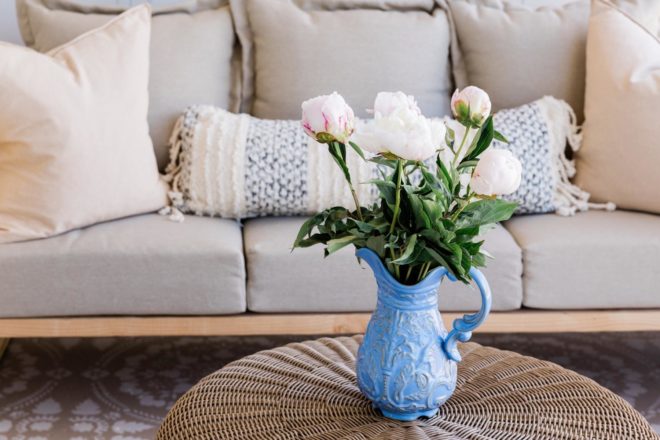 A pitcher of fresh flowers on a living room chair.