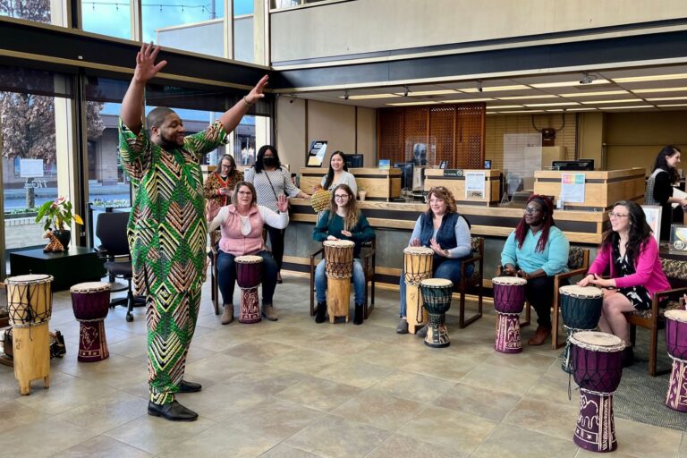 OlyFed employees during interactive drumming demonstration with the Hawk Foundation