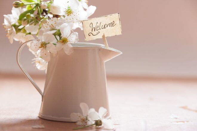 Pitcher with Welcome sign and spring flowers