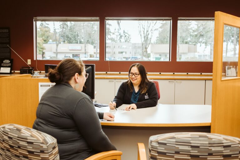 Trina sitting with a customer opening a checking account.