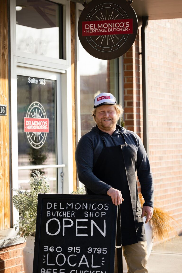 Owner of Delmonico's Heritage Butcher in front of shop in Olympia
