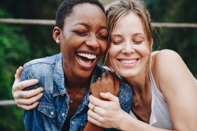 Friends that are laughing and hugging.