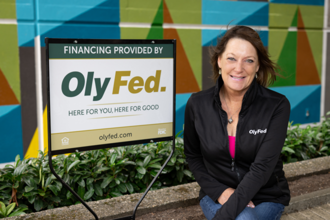 Michelle Eddy in front of an Olyfed sign in the drive-thru