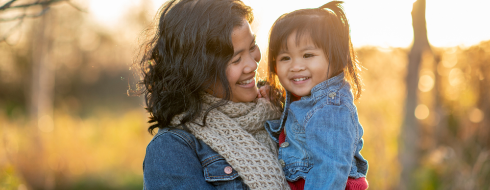 A mom and child by fall trees