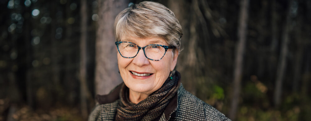 Woman standing in front of wooded area