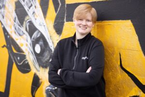 Person standing in front of bee mural