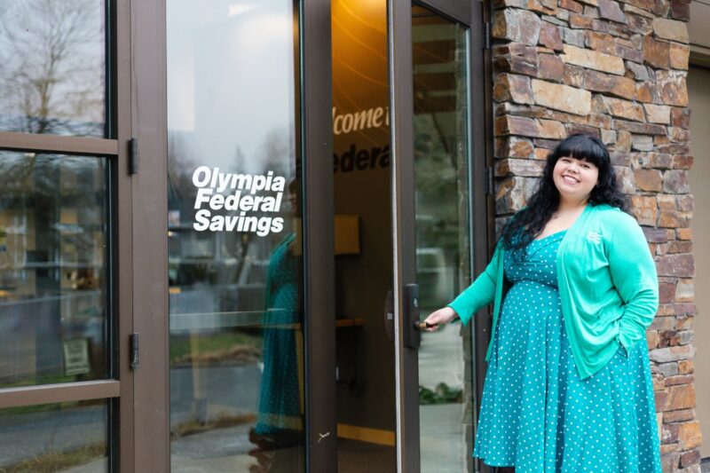 Woman opening door of OlyFed branch