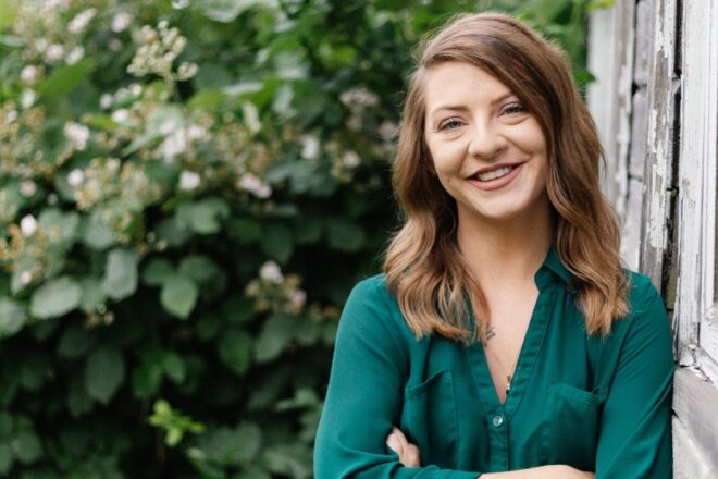 OlyFed Employee standing in front of greenery