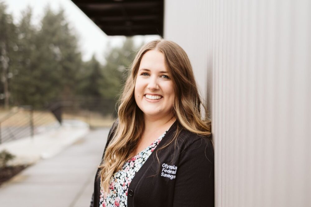 Smiling woman leaning against wall of building
