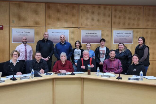 Group of Yelm students and community members post for photo at school board meeting