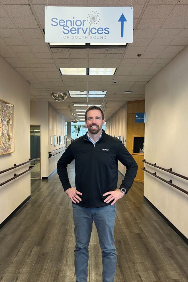 Man standing in hallway under Senior Services sign