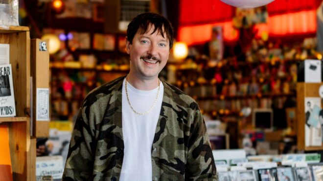 Man smiling standing in record store