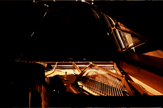 Piano with lid open and orange light showing underneath lid