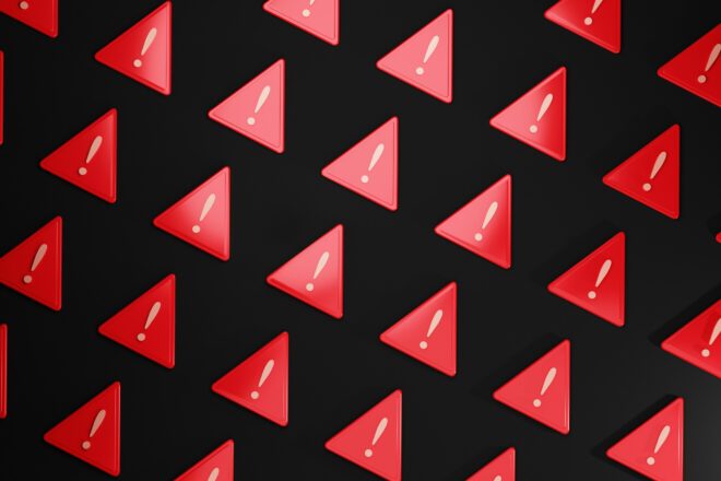 A bunch of red warning triangles in diagonal line patterns with exclamation points in the center on top of a black background.