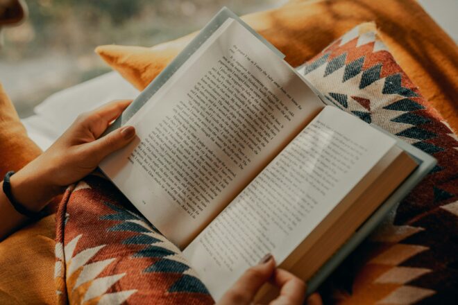 Someone reading a book on a pillow, warm tones