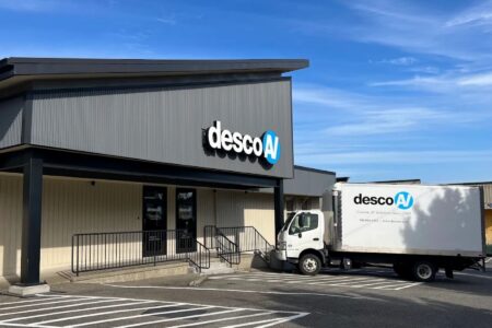 Storefront with truck parked in front. Both building and truck read: desco av.