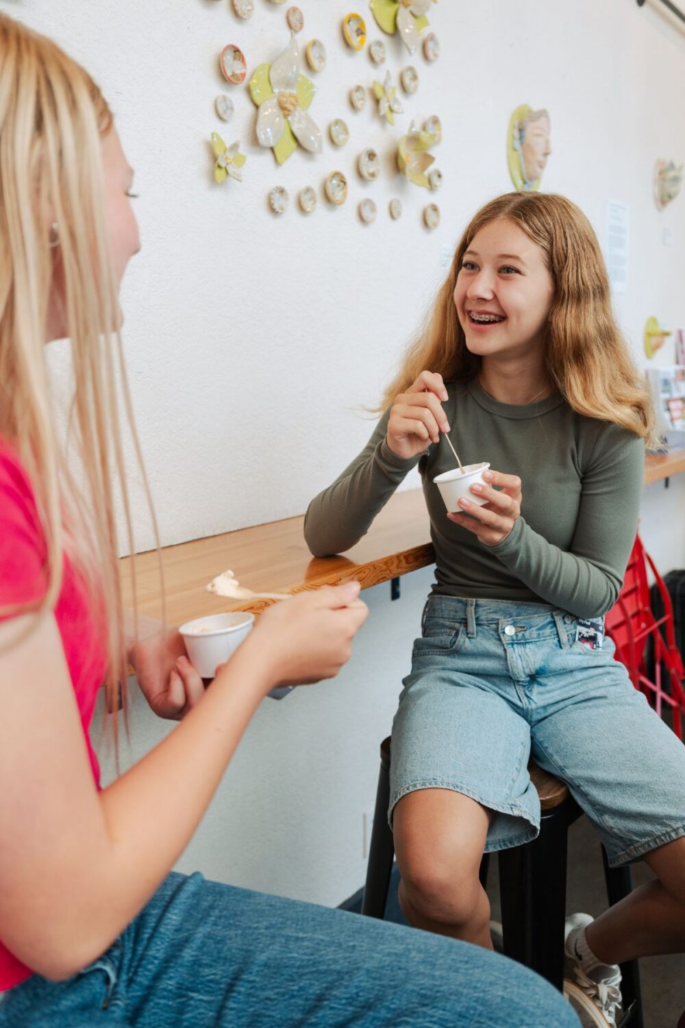 Two teenage girls smiling and eating ice cream
